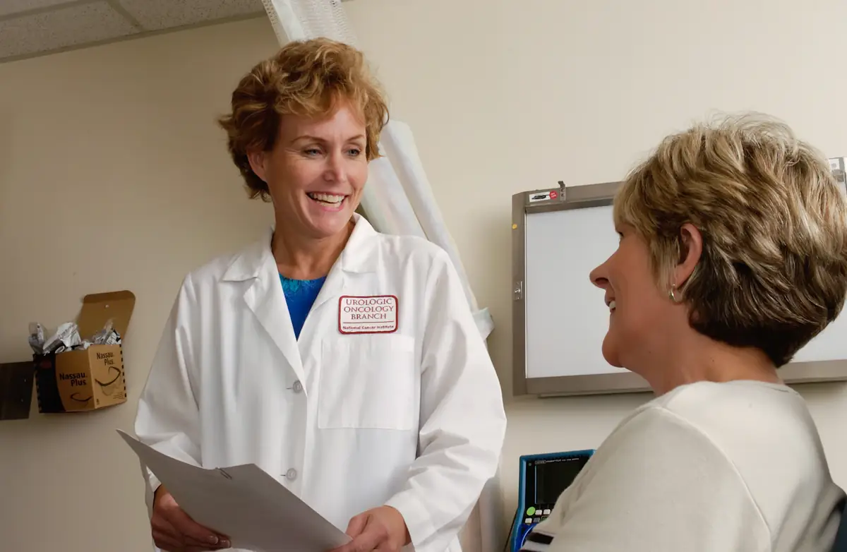 A doctor in a white coat talking a patient through her notes