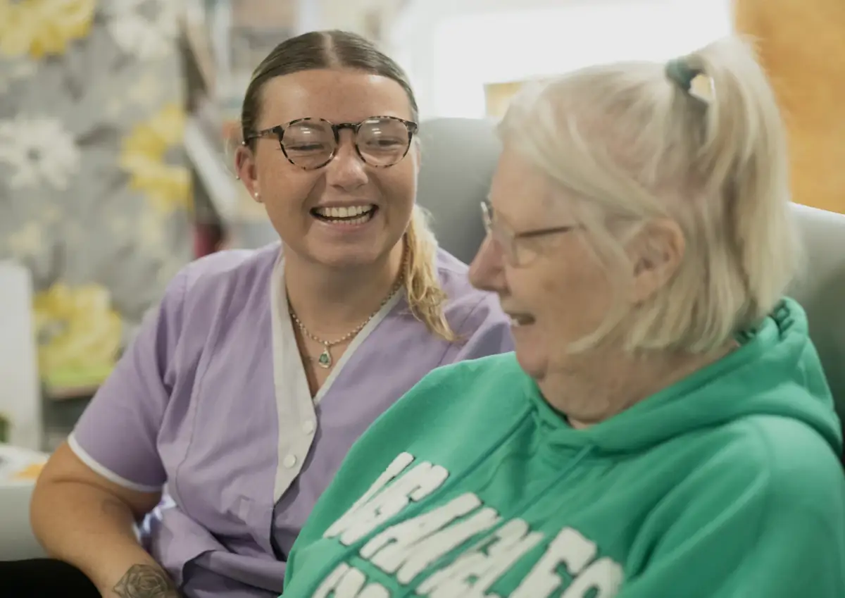 A carer sharing a laugh with an elderly resident