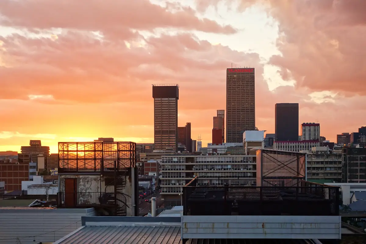 Johannesburg's skyline against an orange evening sky