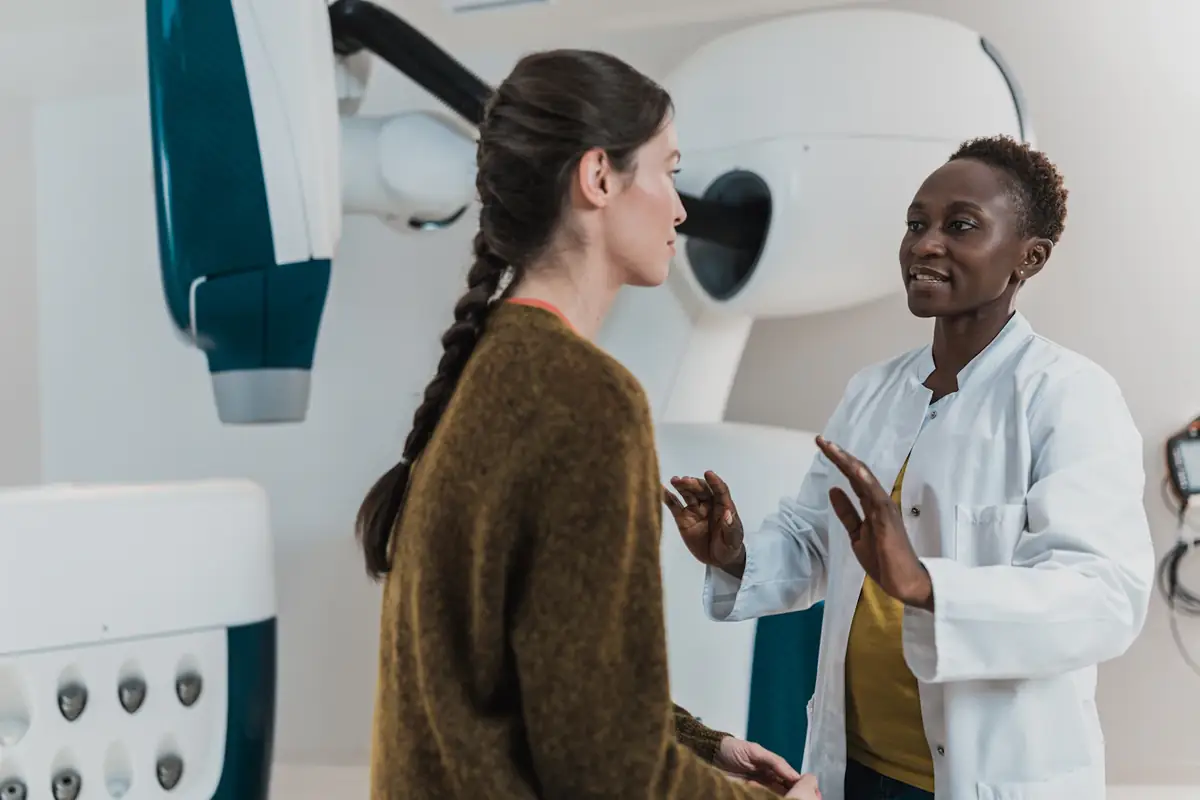 A doctor talking with a patient beside a scanner