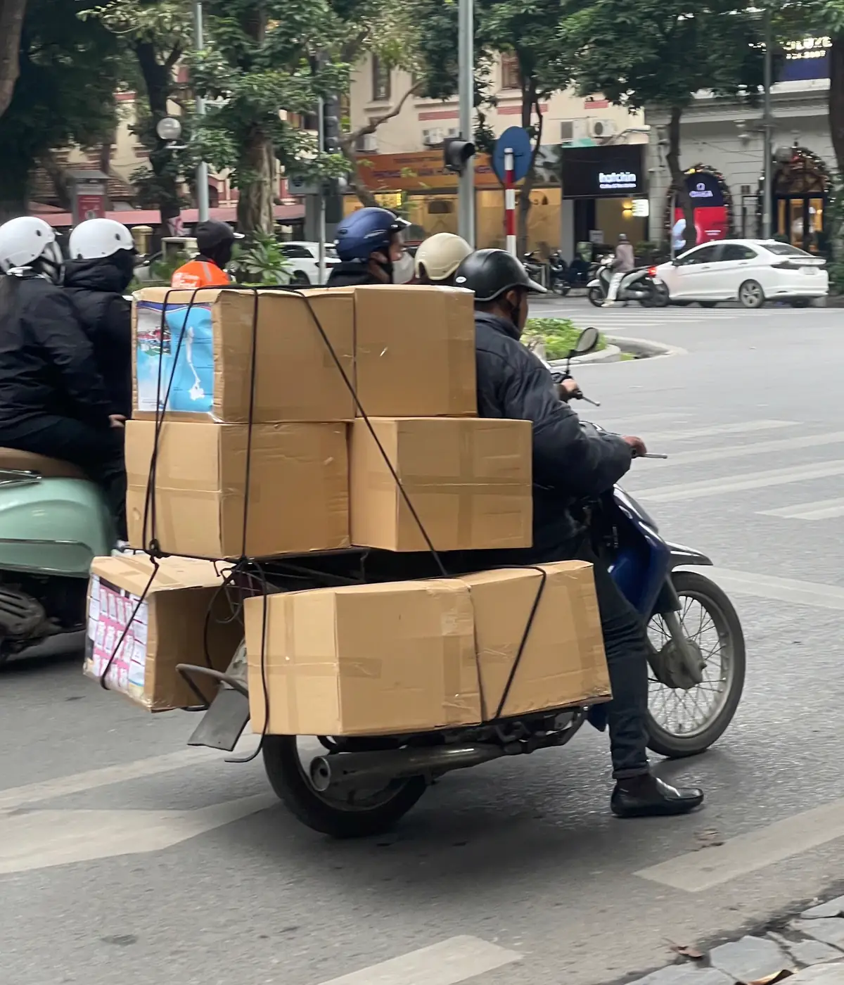 A motorbike loaded high with boxes in traffic
