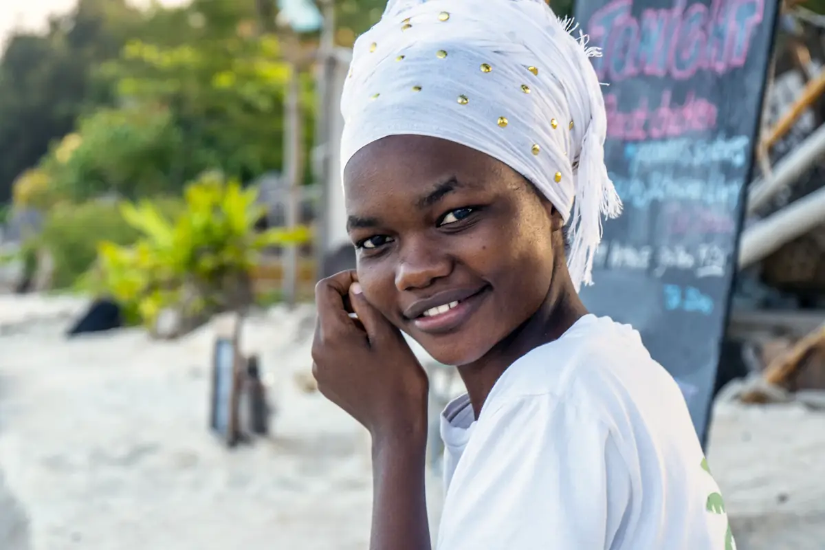 A woman in a headscarf smiling as she talks on the phone