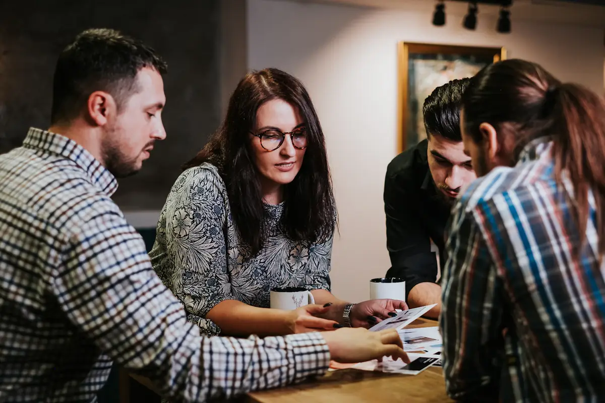 Colleagues leaning over a table, talking a quote through